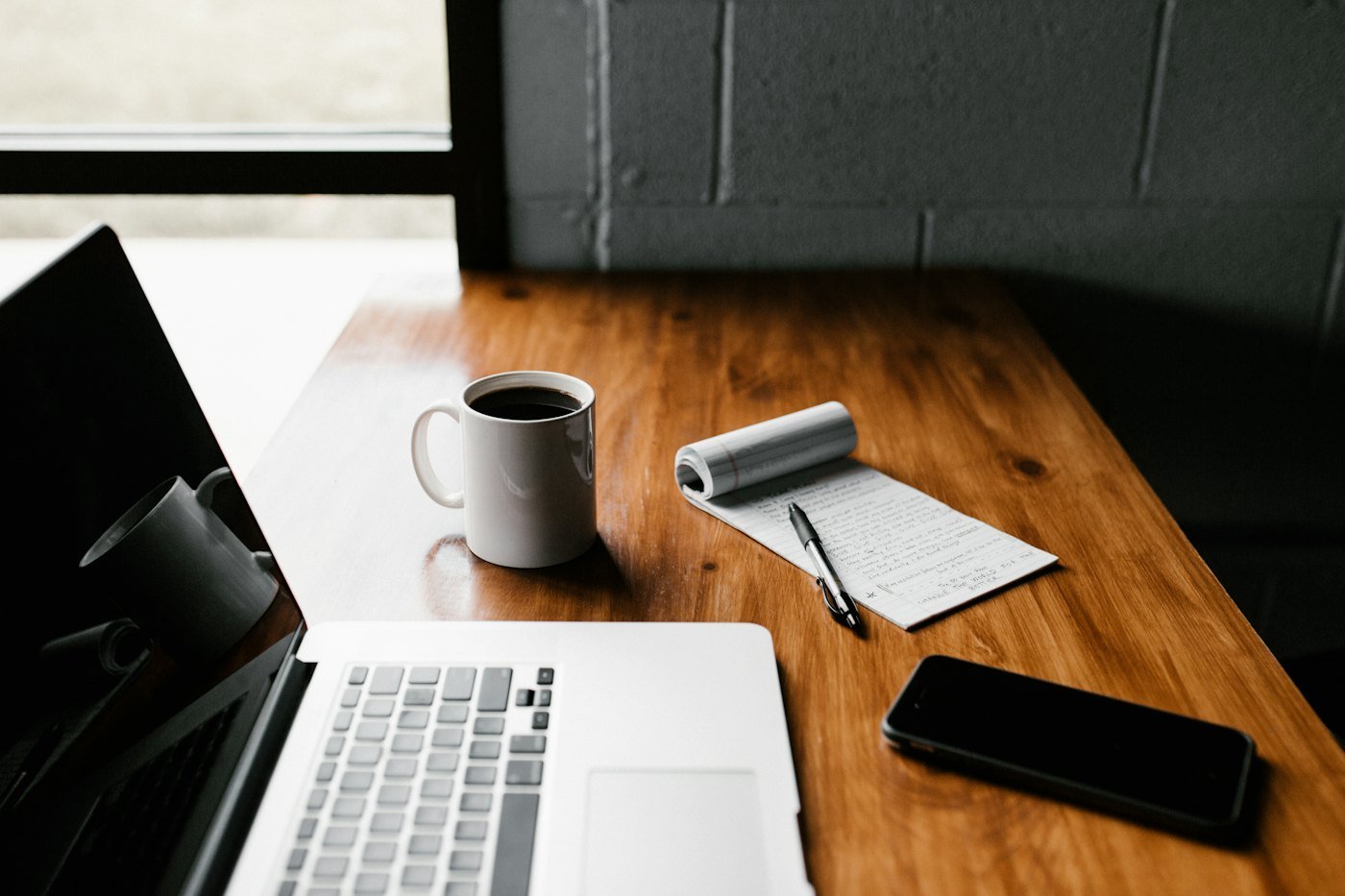 Laptop, coffee and notes on a desk in a modern workspace